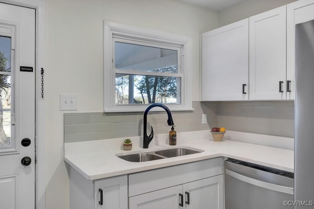 kitchen featuring a sink, tasteful backsplash, appliances with stainless steel finishes, white cabinets, and light countertops