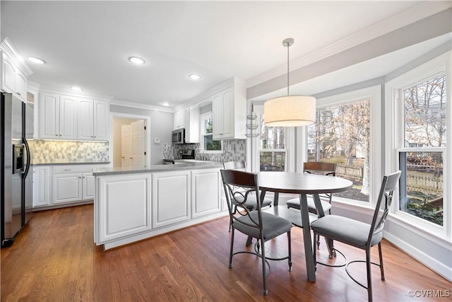 dining space with recessed lighting, baseboards, wood finished floors, and ornamental molding