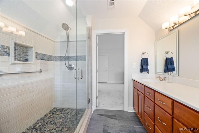 full bath featuring vanity, lofted ceiling, visible vents, and a stall shower