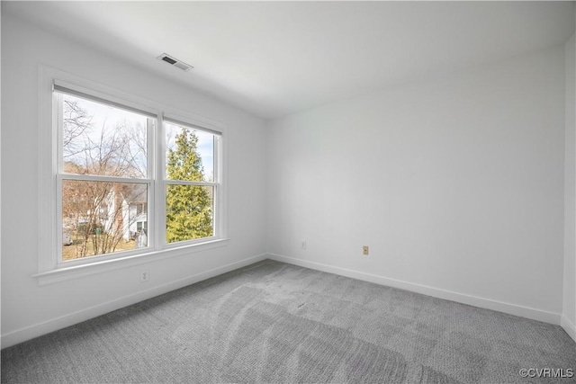 carpeted empty room with visible vents and baseboards