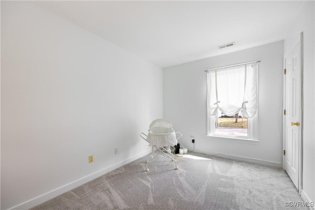 carpeted empty room featuring visible vents and baseboards