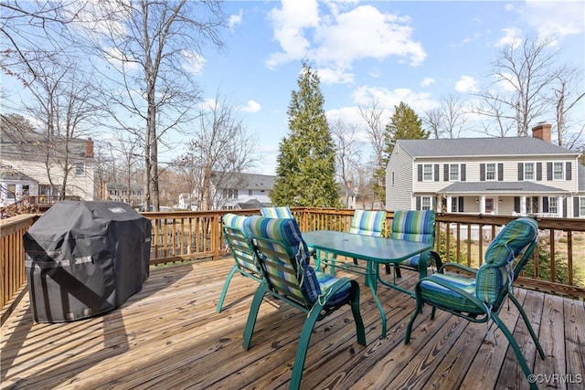 wooden terrace with a grill and outdoor dining space