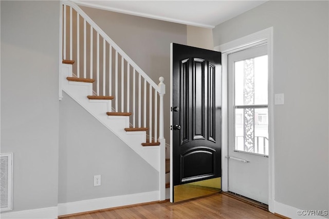 entryway featuring stairway, baseboards, and wood finished floors