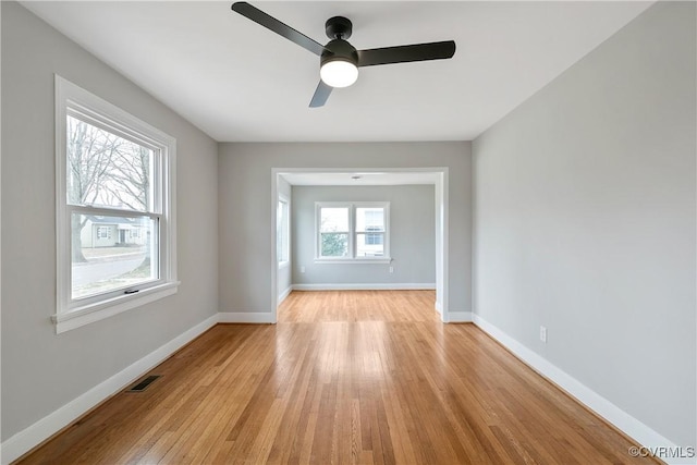 unfurnished room with visible vents, baseboards, ceiling fan, and light wood finished floors