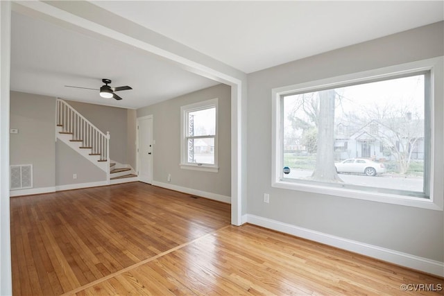 entrance foyer with visible vents, baseboards, stairs, hardwood / wood-style flooring, and a ceiling fan