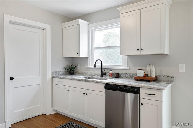 kitchen with dishwasher, white cabinets, wood finished floors, and a sink