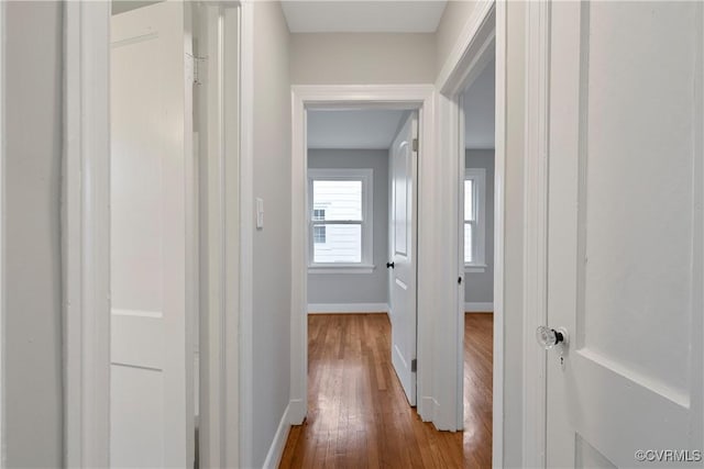 corridor with baseboards and dark wood-style floors