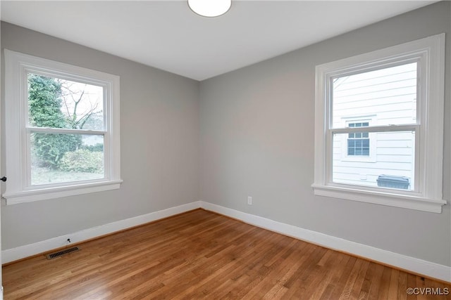 unfurnished room with light wood-style flooring, baseboards, and visible vents