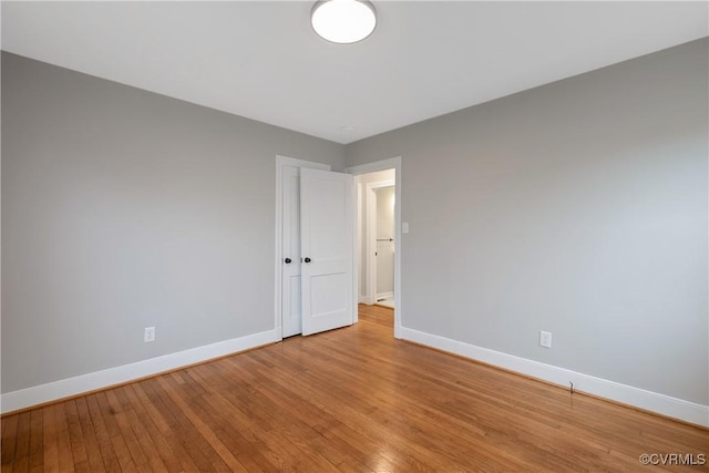 empty room with baseboards and light wood-style flooring