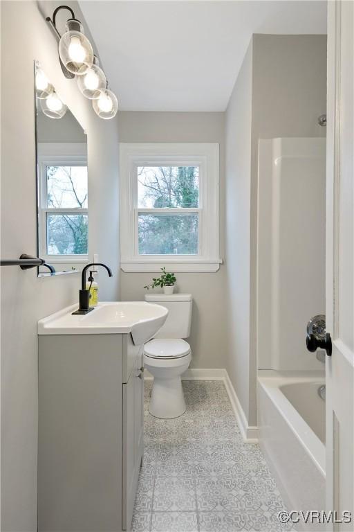 bathroom featuring tile patterned flooring, tub / shower combination, baseboards, toilet, and vanity