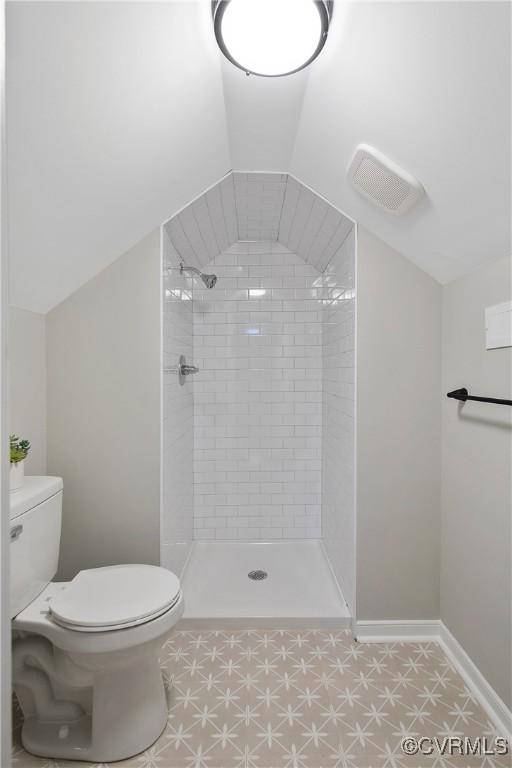 full bath with visible vents, toilet, lofted ceiling, a shower stall, and baseboards