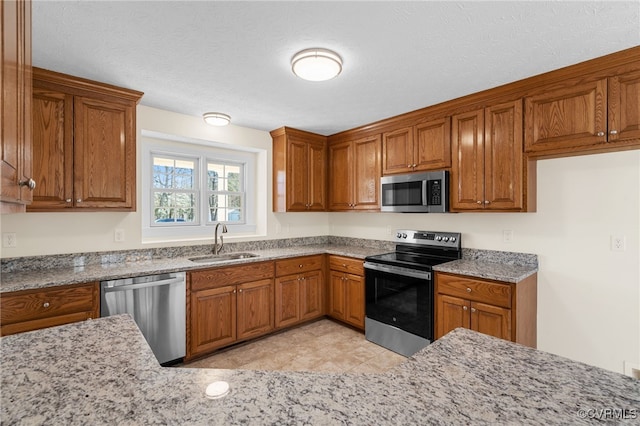 kitchen featuring a sink, stainless steel appliances, and brown cabinetry