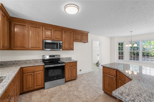 kitchen with light stone countertops, brown cabinets, and appliances with stainless steel finishes