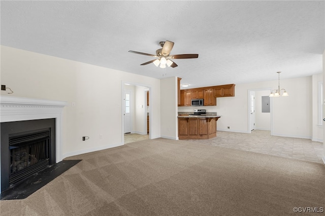 unfurnished living room with light carpet, a fireplace with flush hearth, ceiling fan with notable chandelier, electric panel, and a textured ceiling