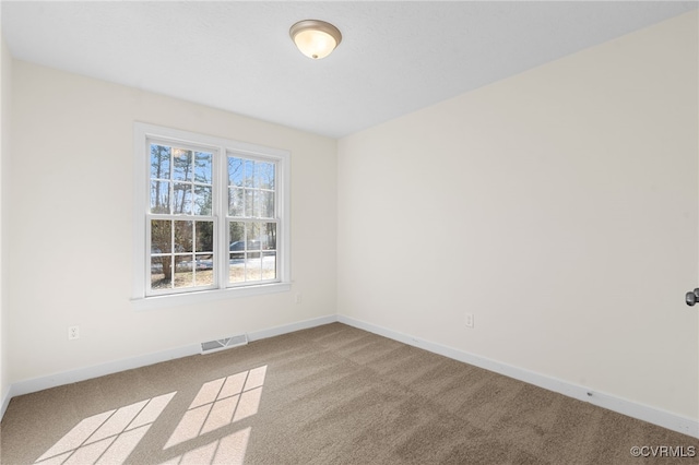 unfurnished room featuring visible vents, carpet floors, and baseboards