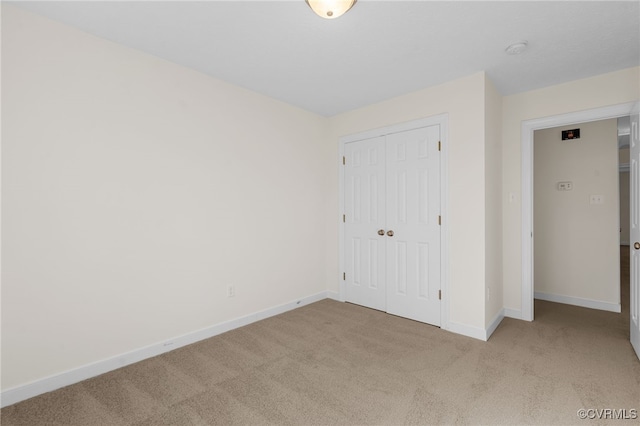 unfurnished bedroom with a closet, baseboards, and carpet flooring