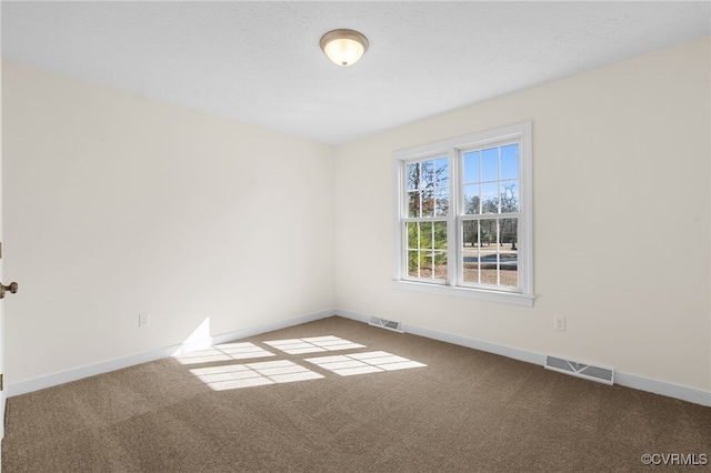 unfurnished room featuring carpet, visible vents, and baseboards