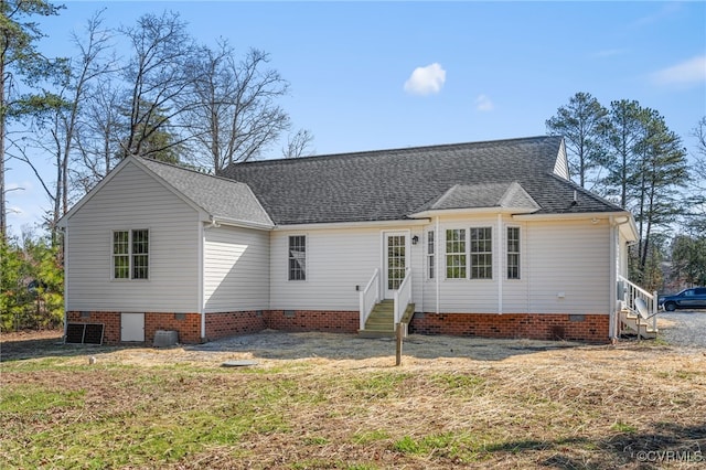 rear view of house with crawl space, a lawn, entry steps, and a shingled roof