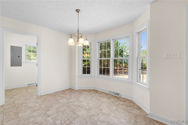 spare room with an inviting chandelier, electric panel, baseboards, and visible vents