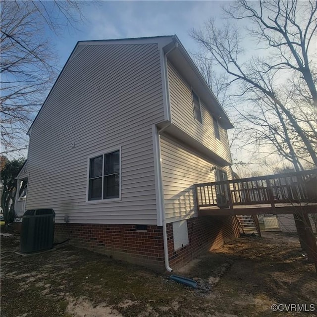 view of property exterior with central air condition unit and a wooden deck