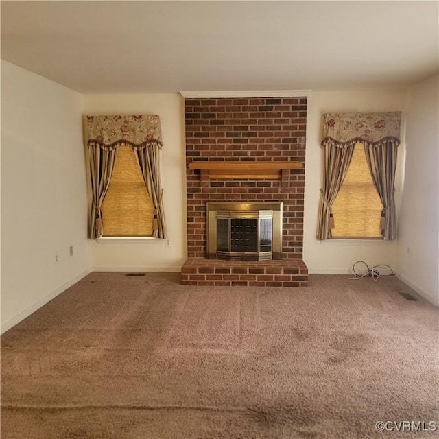 unfurnished living room with visible vents, baseboards, a fireplace, and carpet flooring