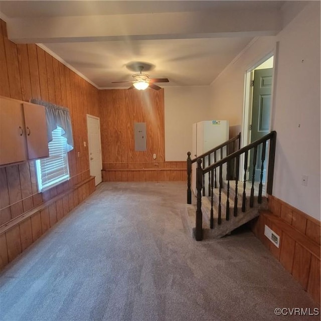 unfurnished room with crown molding, beamed ceiling, carpet, and wood walls