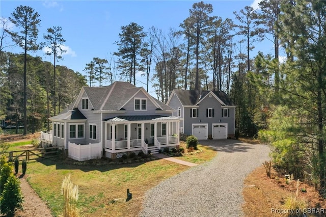 view of front facade with a front yard, fence, gravel driveway, an attached garage, and covered porch