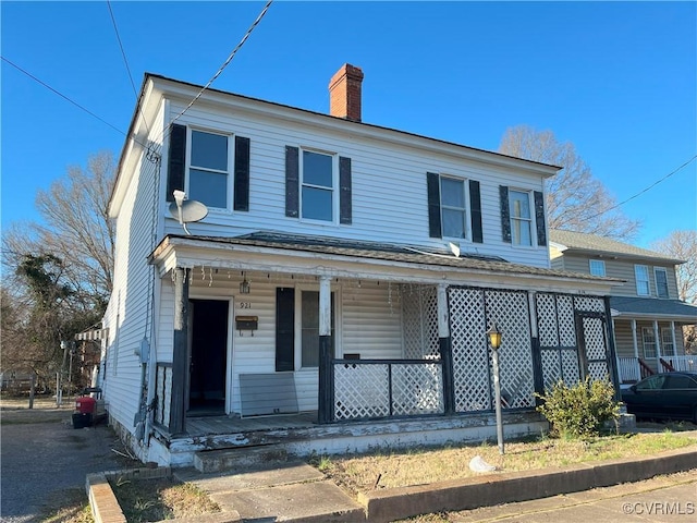 view of front of home with covered porch and a chimney