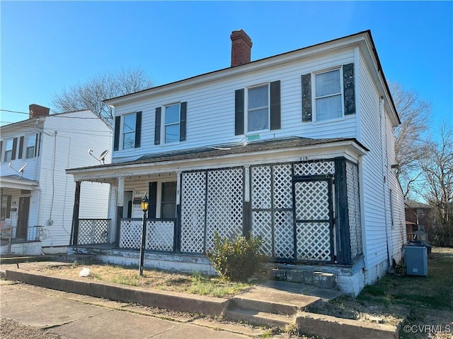 view of front of home with covered porch and a chimney