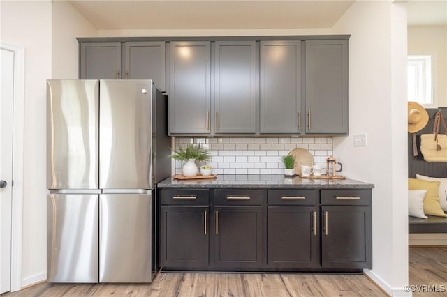 8160 Lyman Ct, Mechanicsville, VA 23116 - kitchen with freestanding refrigerator, dark stone counters, light wood-style flooring, decorative backsplash, and gray cabinets