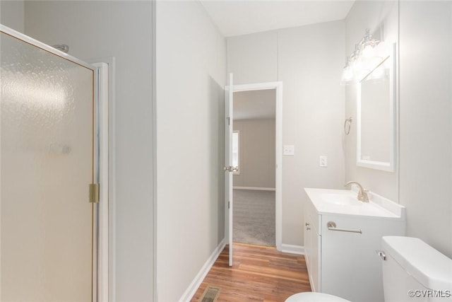 full bath with vanity, wood finished floors, visible vents, a shower stall, and toilet