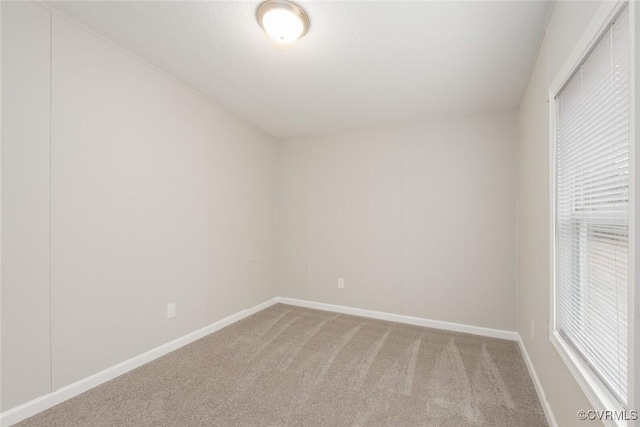 carpeted empty room with baseboards and plenty of natural light