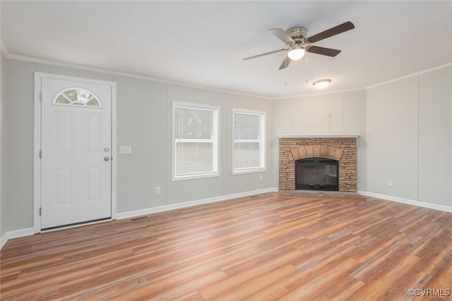 unfurnished living room featuring a wealth of natural light, light wood-type flooring, a ceiling fan, and ornamental molding