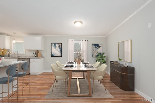 dining area with light wood-style floors, baseboards, and ornamental molding