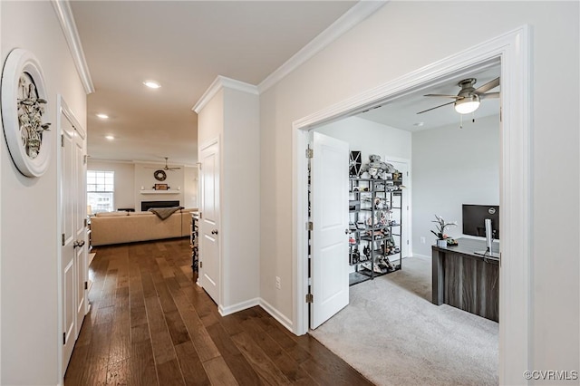 hallway with dark wood-style flooring, recessed lighting, baseboards, and ornamental molding