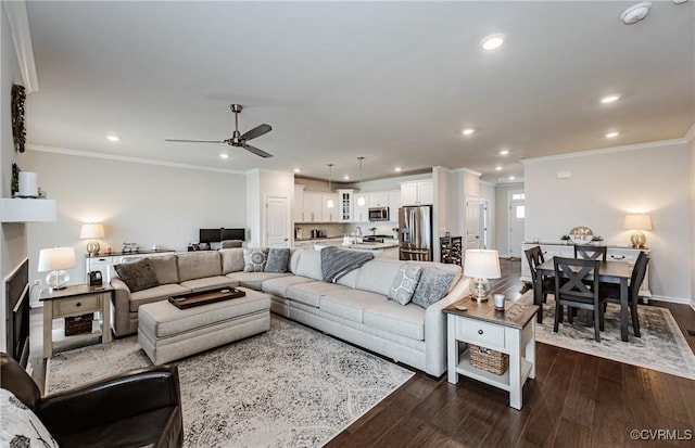 living area featuring recessed lighting, dark wood-type flooring, ceiling fan, and ornamental molding