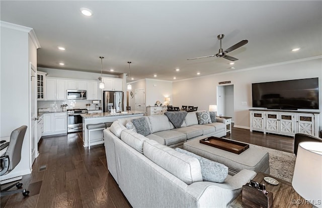 living room featuring dark wood-style floors, ceiling fan, and ornamental molding