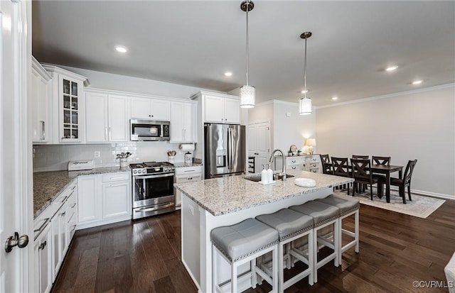 kitchen featuring dark wood finished floors, stainless steel appliances, tasteful backsplash, and a sink