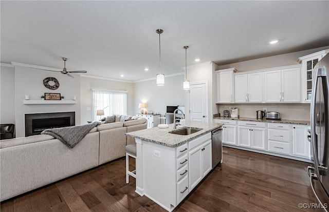 kitchen with dark wood finished floors, ceiling fan, a sink, appliances with stainless steel finishes, and open floor plan