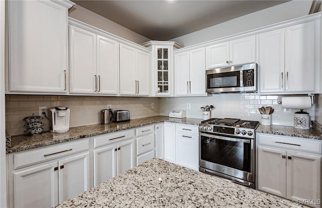 kitchen featuring white cabinets, tasteful backsplash, and appliances with stainless steel finishes