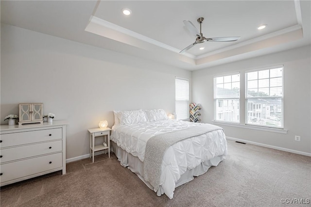 bedroom featuring a tray ceiling, baseboards, and carpet