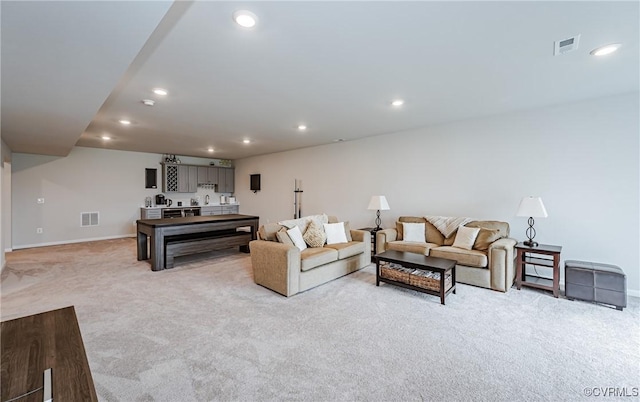 living area featuring light carpet, visible vents, and recessed lighting