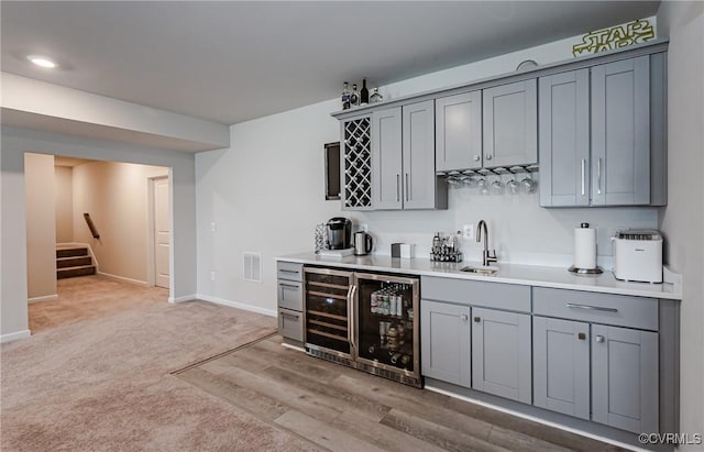 bar featuring stairway, visible vents, a sink, indoor wet bar, and wine cooler