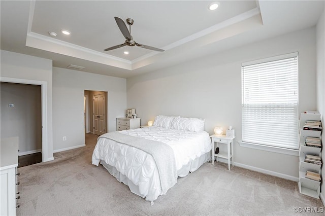 bedroom with light carpet, a tray ceiling, recessed lighting, crown molding, and baseboards