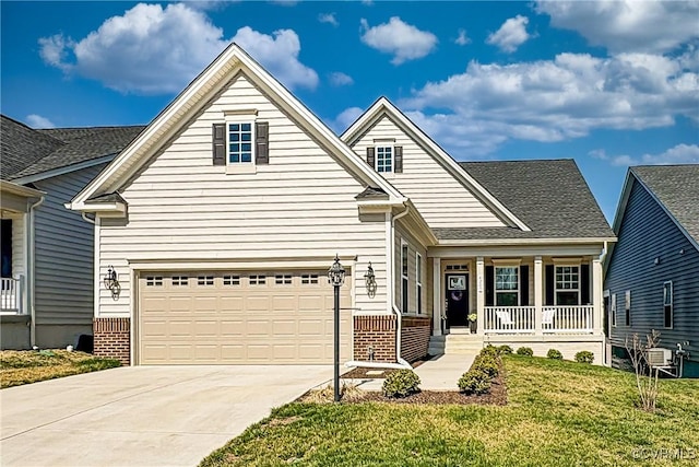 view of front of house with a garage, a front lawn, covered porch, and driveway