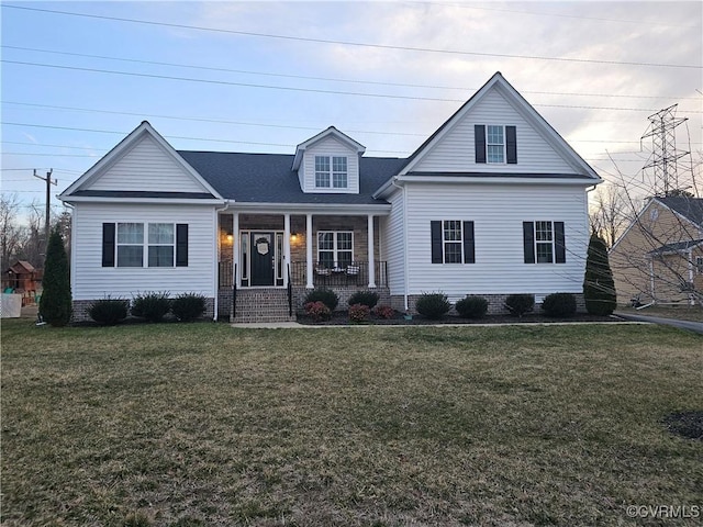 view of front facade featuring covered porch, a front yard, and a shingled roof