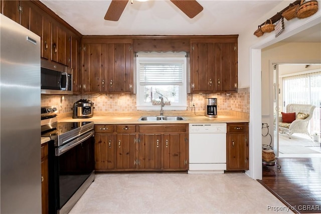 kitchen featuring a healthy amount of sunlight, appliances with stainless steel finishes, light countertops, and a sink