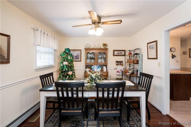 dining room with a baseboard heating unit, wood finished floors, and ceiling fan