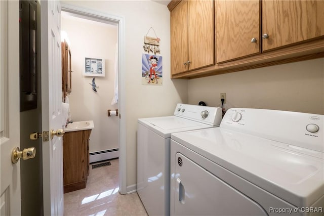 clothes washing area with cabinet space, baseboard heating, and washing machine and clothes dryer