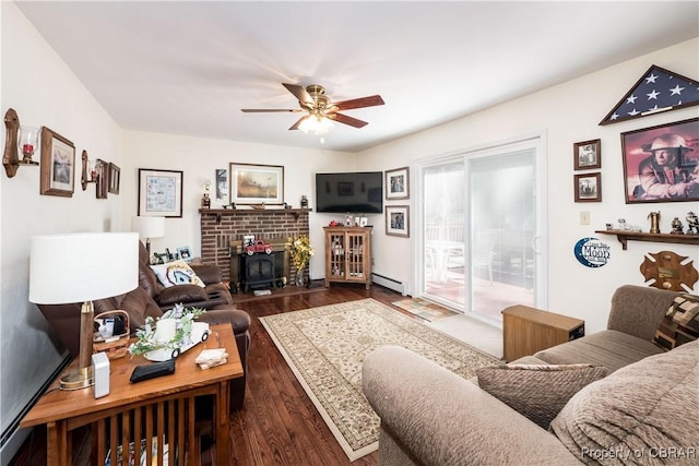 living area with a brick fireplace, wood finished floors, a ceiling fan, and a baseboard radiator